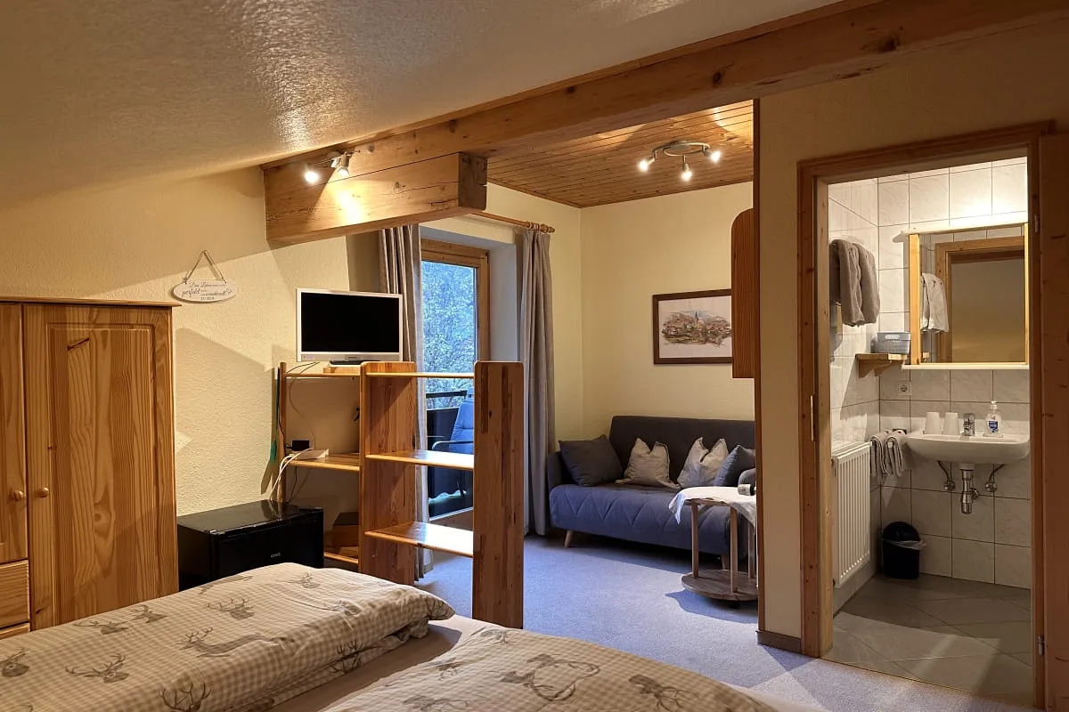 Wohnbereich mit Doppelbett und Badezimmer im Rothorn