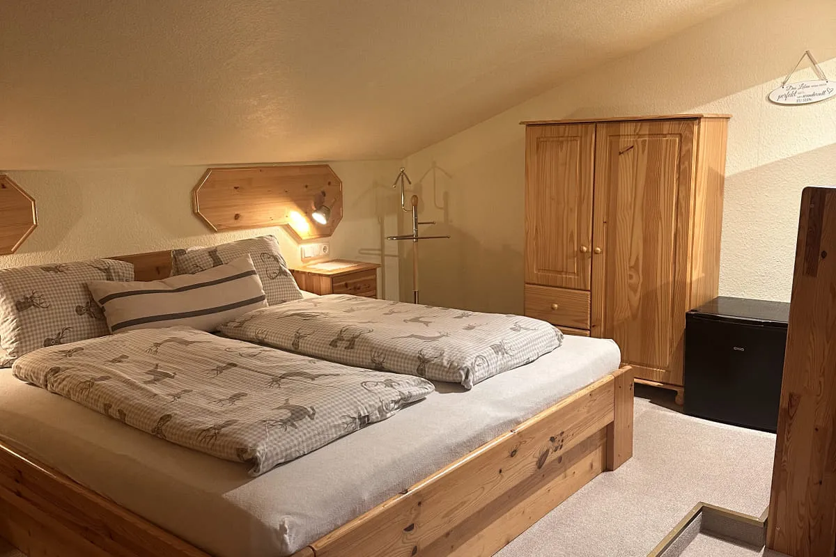 Gemütliches Schlafzimmer mit Doppelbett und Holzschrank